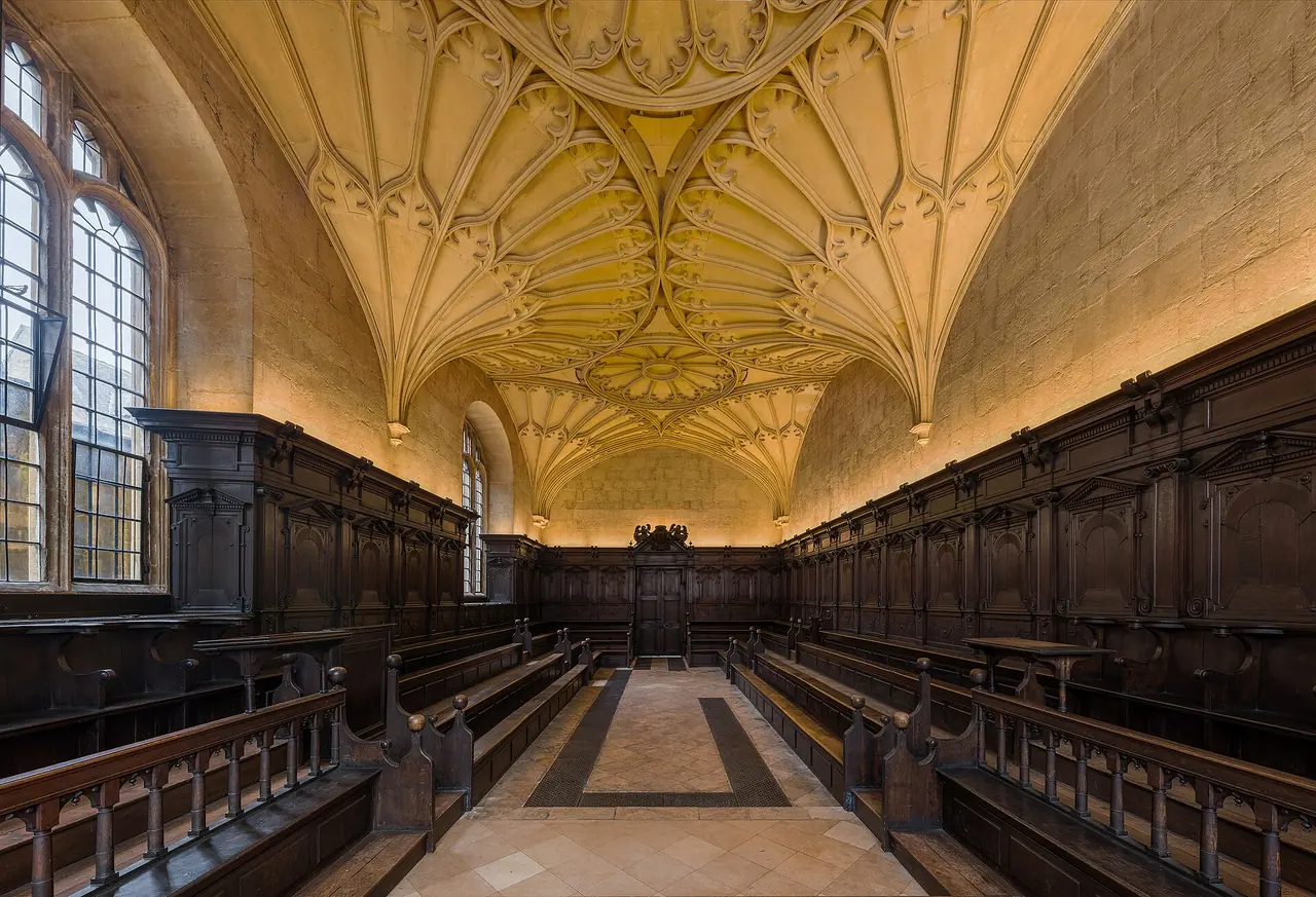 Convocation House, with dark panelled benches facing each other beneath a pale stone fan vault